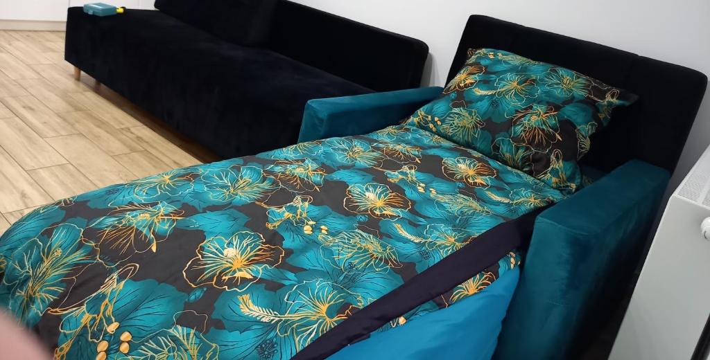 库特诺Apartament Różana Piątka的一张带蓝色棉被和枕头的床