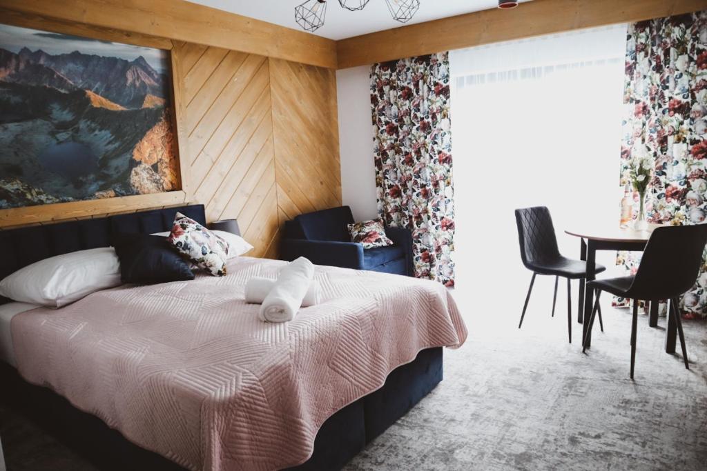 布科维纳-塔钱斯卡Willa Koszysta的卧室配有一张床和一张桌子及椅子