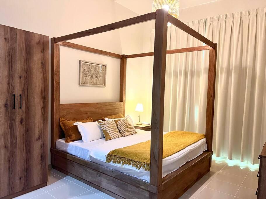 迪拜Calm&Cozy1BR- Dubai Silicon Oasis-15min-Dxb airpt的一间卧室,卧室内配有一张天蓬床