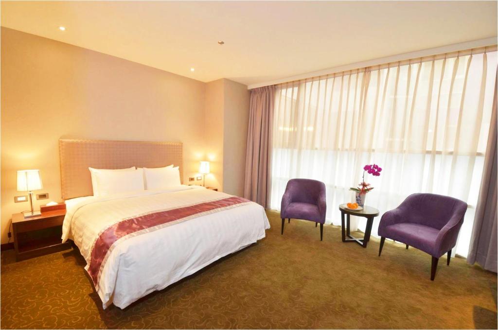 草屯镇福美大饭店 的酒店客房,配有一张床和两张紫色椅子