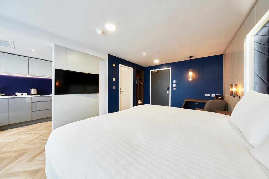 泰恩河畔纽卡斯尔纽卡斯尔市榕目兹酒店的卧室配有白色大床和蓝色的墙壁