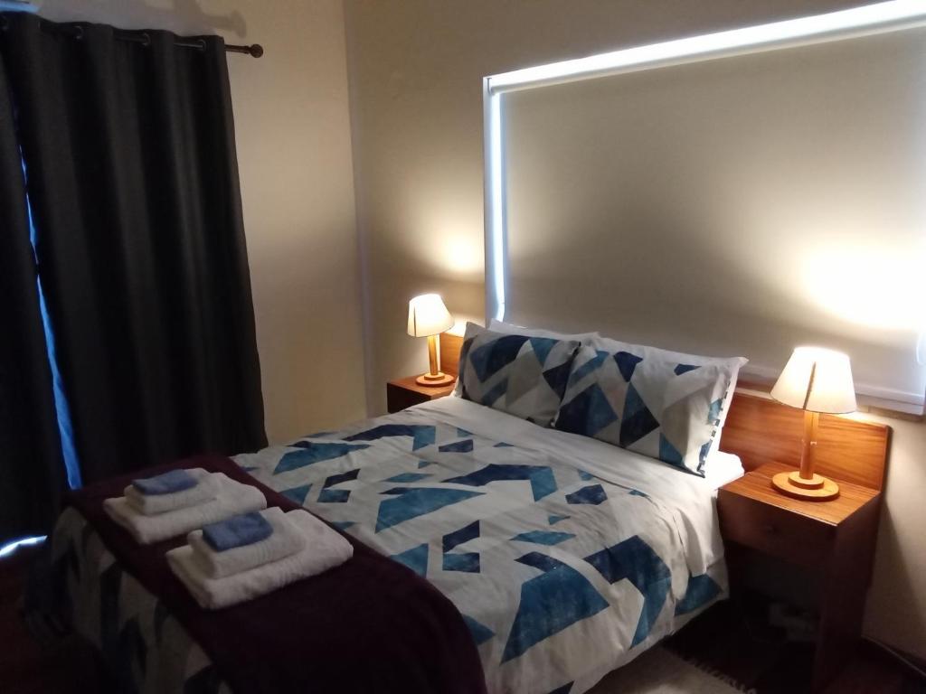 帕尔10 on Fairview B&B的一间卧室配有一张带两盏灯的蓝色和白色的床。