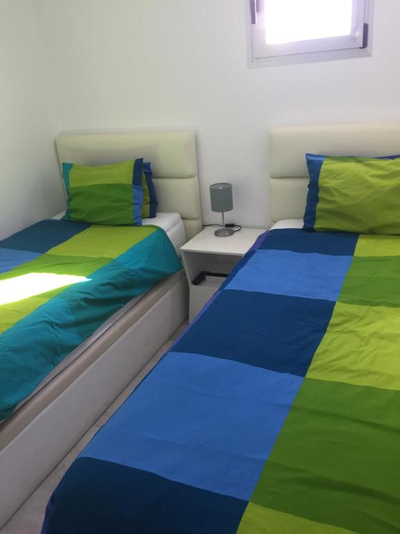 蒂亚斯Los Gracioseras 2 Bed Apt no 218 - AC, WIFI, UK TV的一间卧室配有两张带彩色床单的床