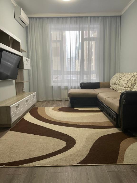 阿斯塔纳Квартира в центре Нур-Султана的带沙发和大地毯的客厅