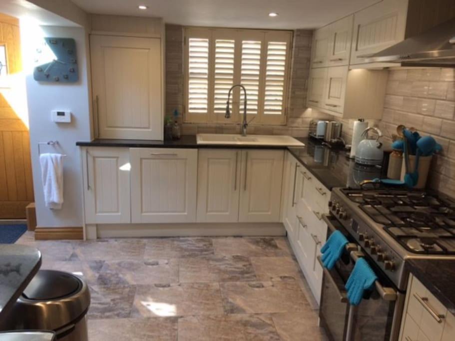 利特尔River Road, Littlehampton, Executive Apartment的厨房配有白色橱柜和炉灶烤箱。