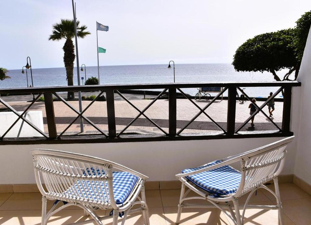 卡门港Casa Regla的两把椅子坐在一个俯瞰着海滩的阳台