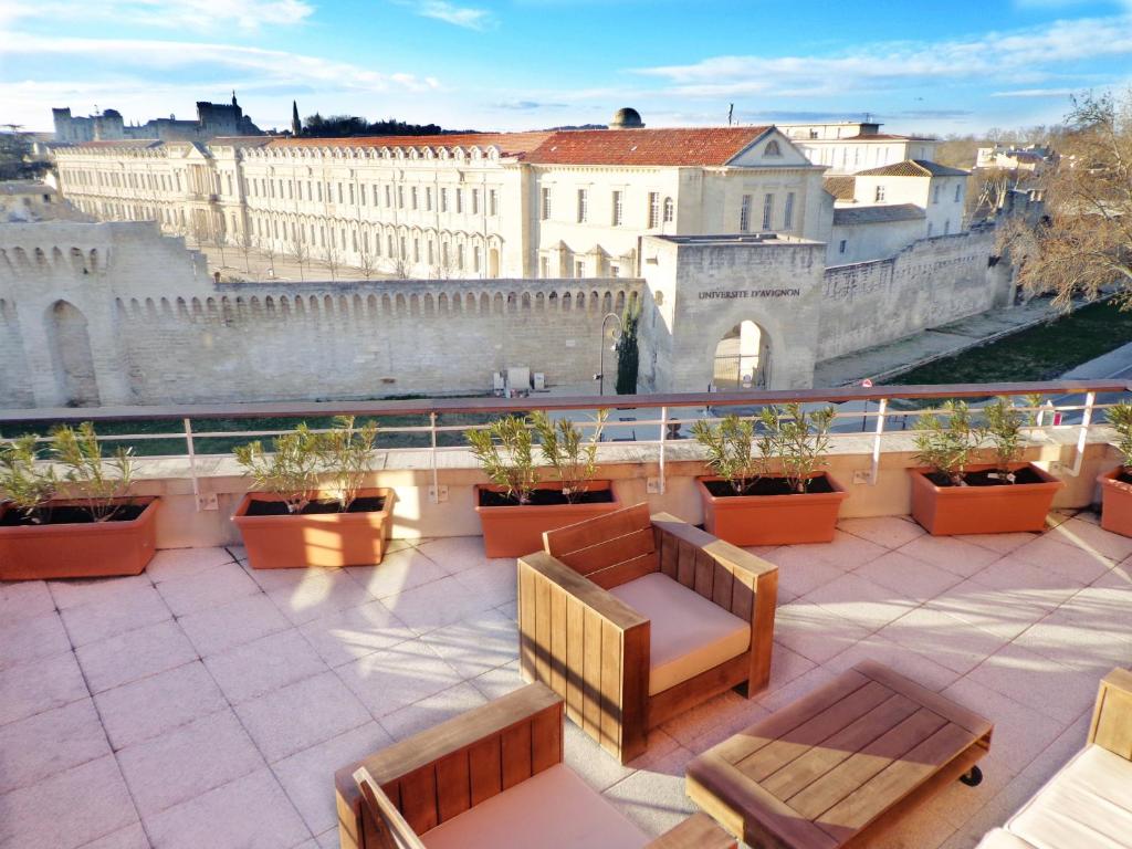 阿维尼翁圣玛尔特公寓式酒店的阳台设有长椅,享有城市美景。