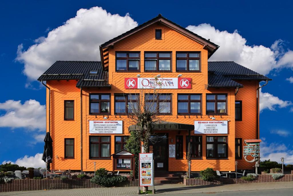 奥伯霍夫Konsum Gästehaus Quisisana - Nebenhaus Berghotel Oberhof - nur Übernachtung的一座橙色的建筑,前面有标志