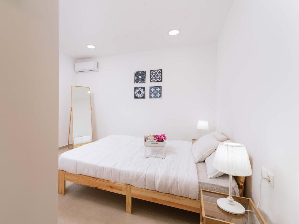 马塔拉Nikkon summer home的白色卧室配有床和镜子