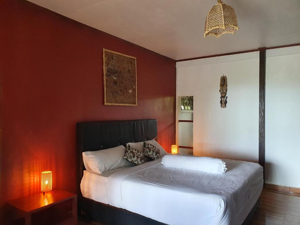 曼诺瓦里Amban Beach House的一间卧室设有一张床和红色的墙壁