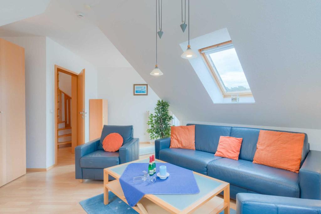 蒂索Strandhaus Thiessow Whg_ 3的客厅配有蓝色的沙发和桌子