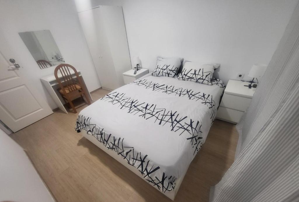 巴达洛纳Habitaciones con baño compartido en bonito Apartamento en Badalona的一间卧室配有一张黑白床单