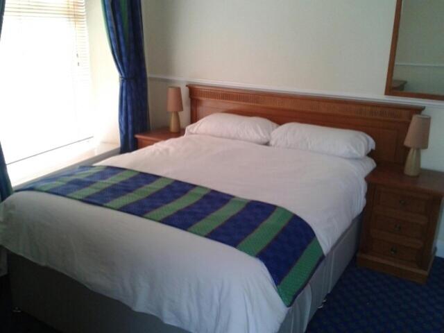 北安普敦格拉夫顿客房酒店的床上有蓝色的绿色条纹毯子