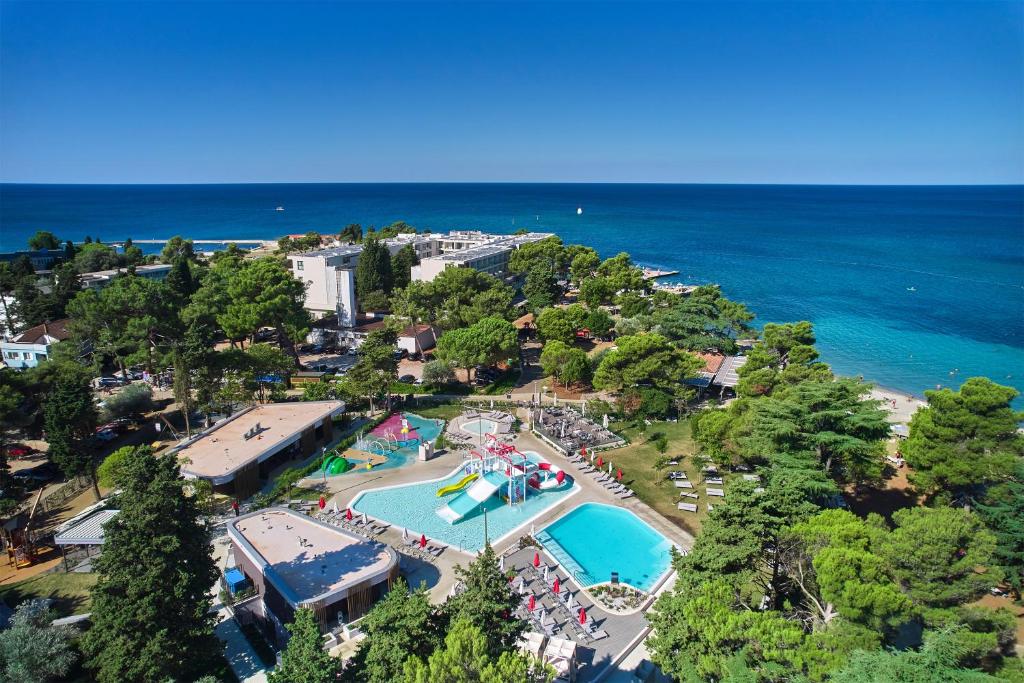 乌马格Hotel Sipar Plava Laguna的享有带游泳池和大海的度假村的顶部景致