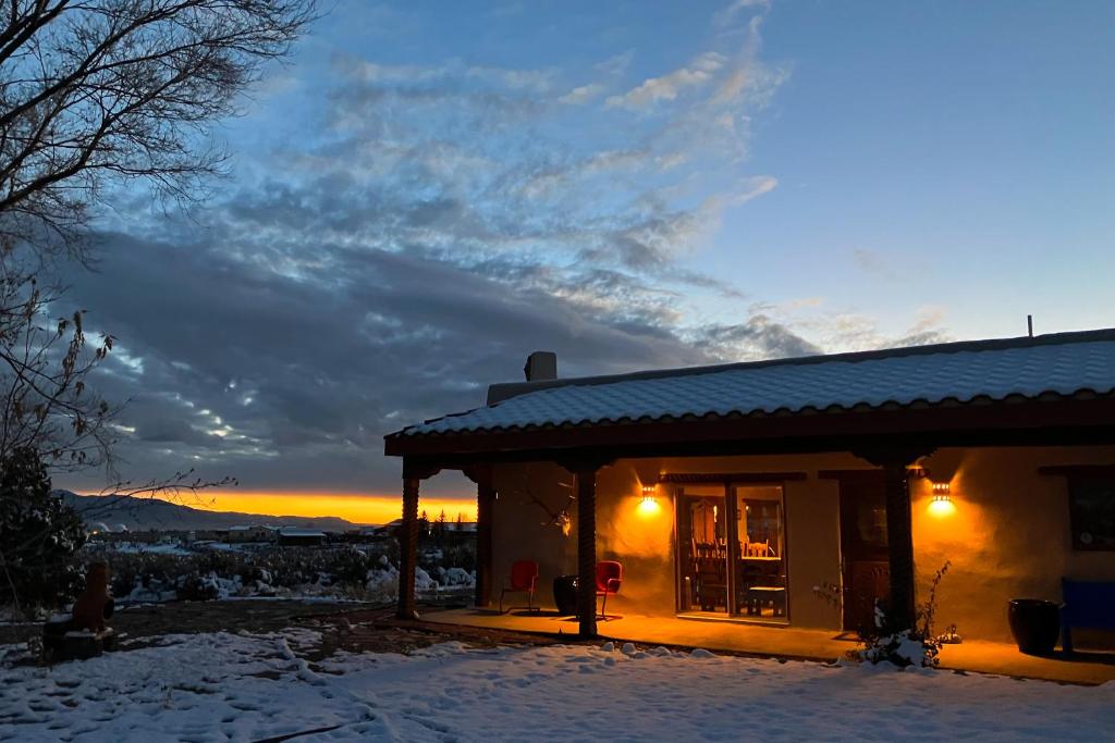 El PradoValerio Dreams的雪中的房子,背景是日落