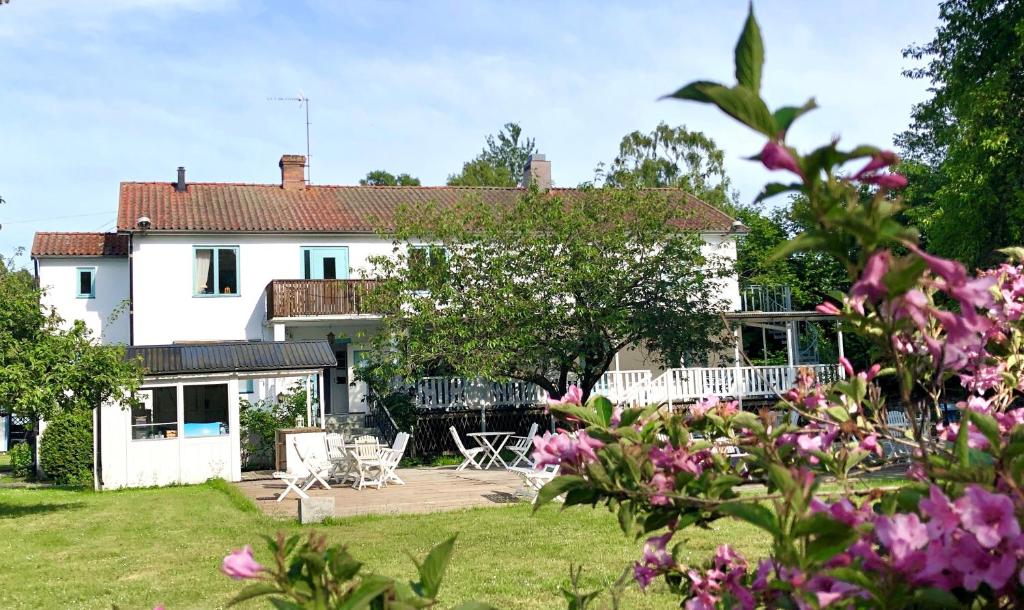 BurgsvikGåsen Out的白色的房子,带粉红色花的院子