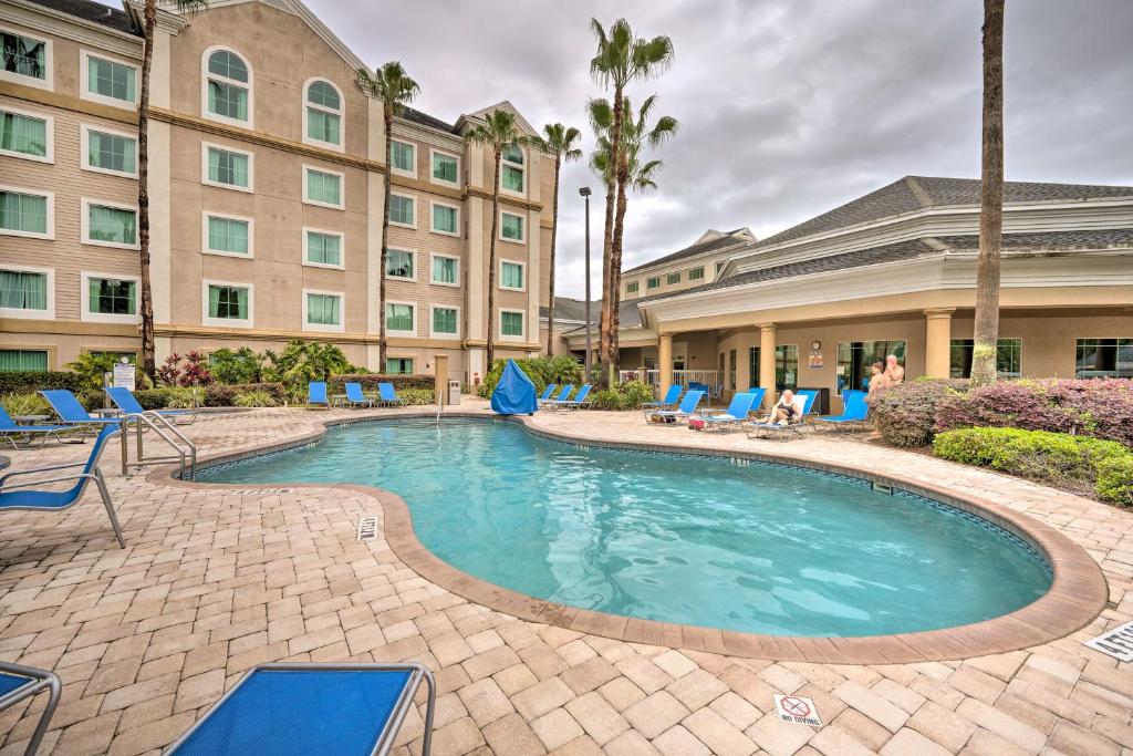 奥兰多Orlando Family Condo about 9 Mi to Magic Kingdom!的一座带椅子的酒店游泳池,一座建筑