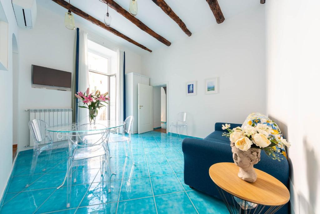 阿马尔菲Amalfi Ammorè的客厅配有玻璃桌和蓝色瓷砖