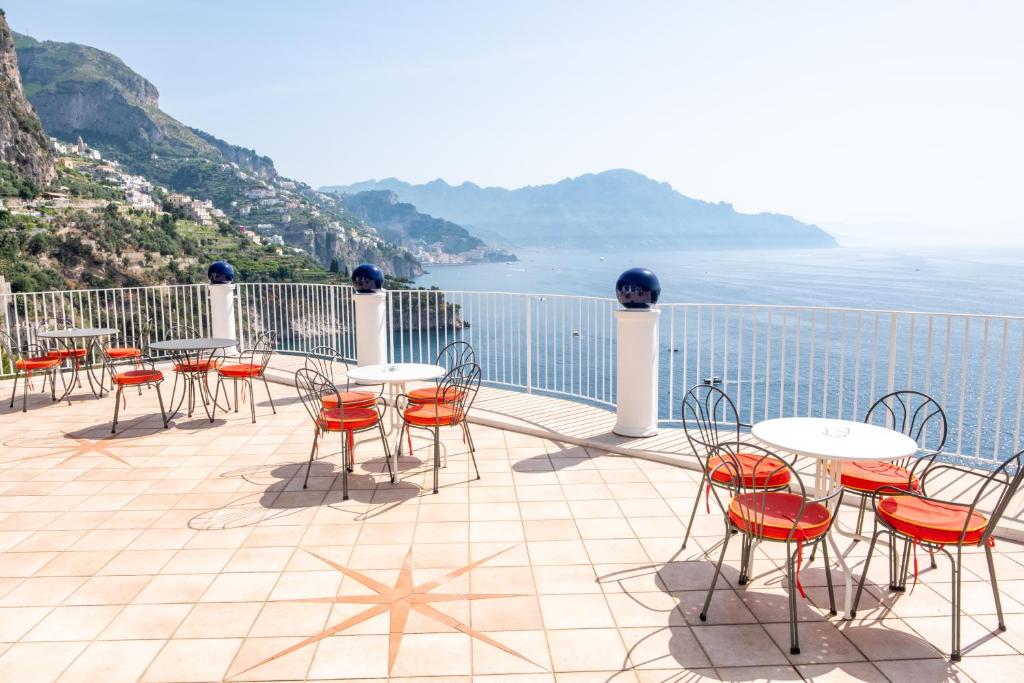 康加德马里尼里特拉切酒店的一个带桌椅的庭院,俯瞰着大海