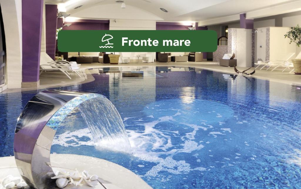 里米尼Yes Hotel Touring & SPA的酒店大堂的室内游泳池,设有瀑布