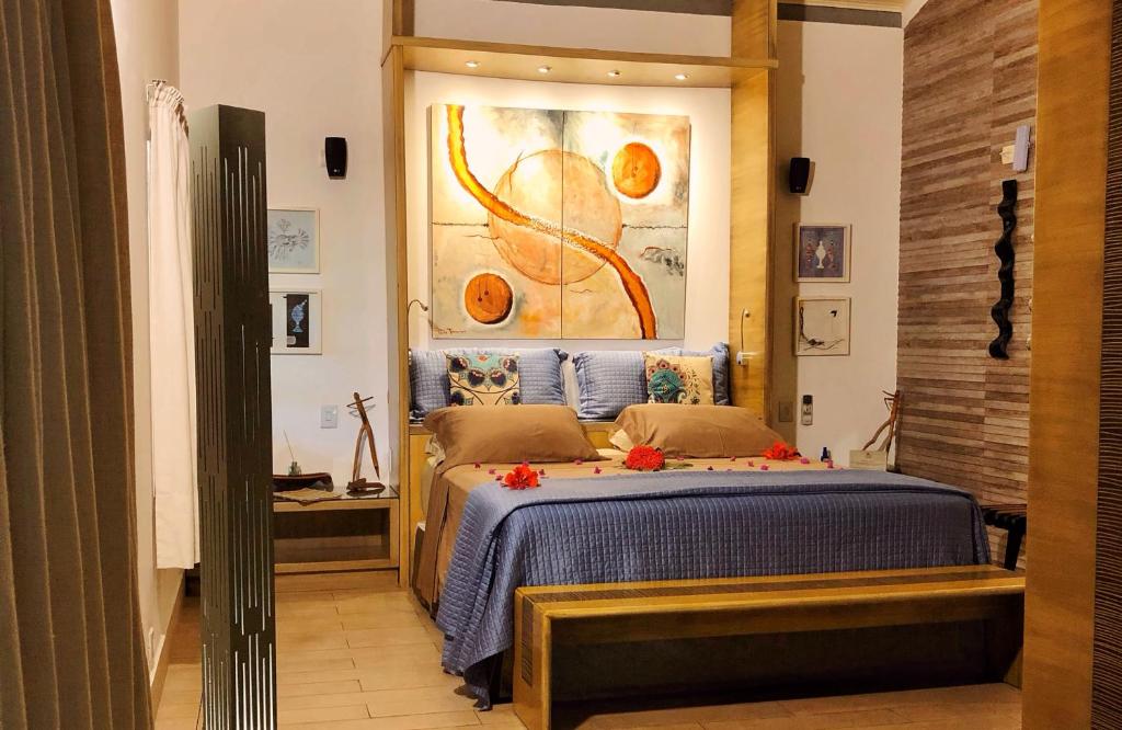 圣米格尔-杜斯米拉格里斯CASA ACAYU的卧室配有一张床,墙上挂有绘画作品
