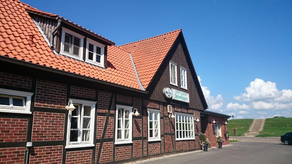 DamnatzHotel Steinhagen的一座建筑,设有红色屋顶和白色窗户