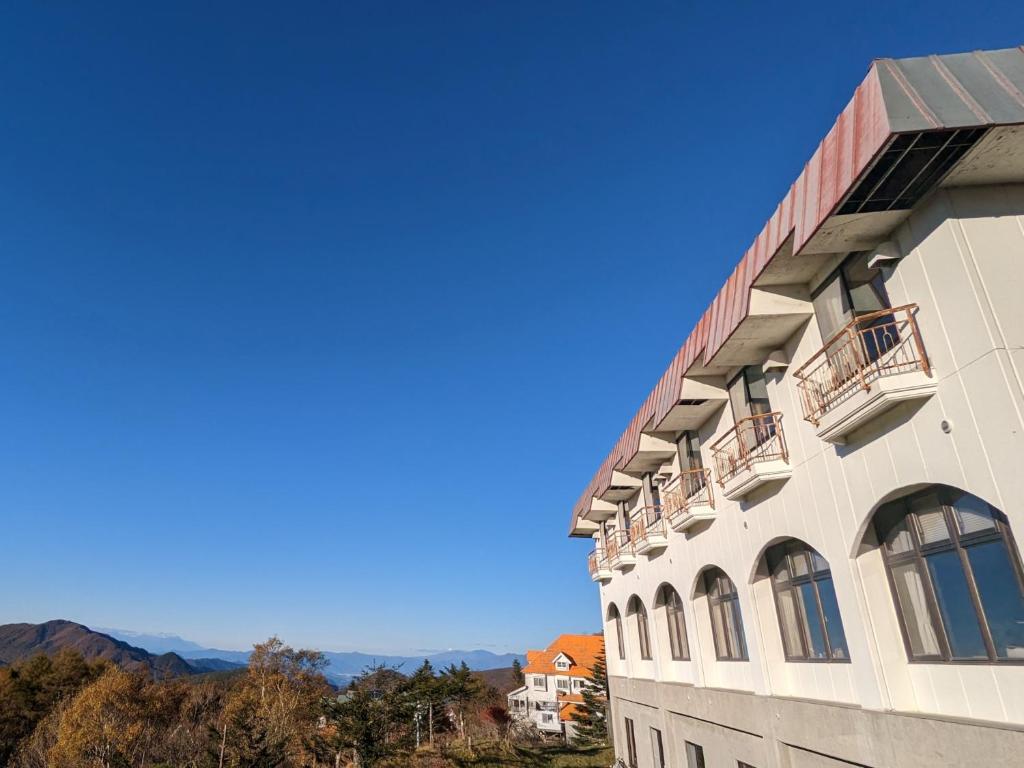 茅野Hotel BergHeil ホテルベルクハイル的享有背景山景建筑的景致。