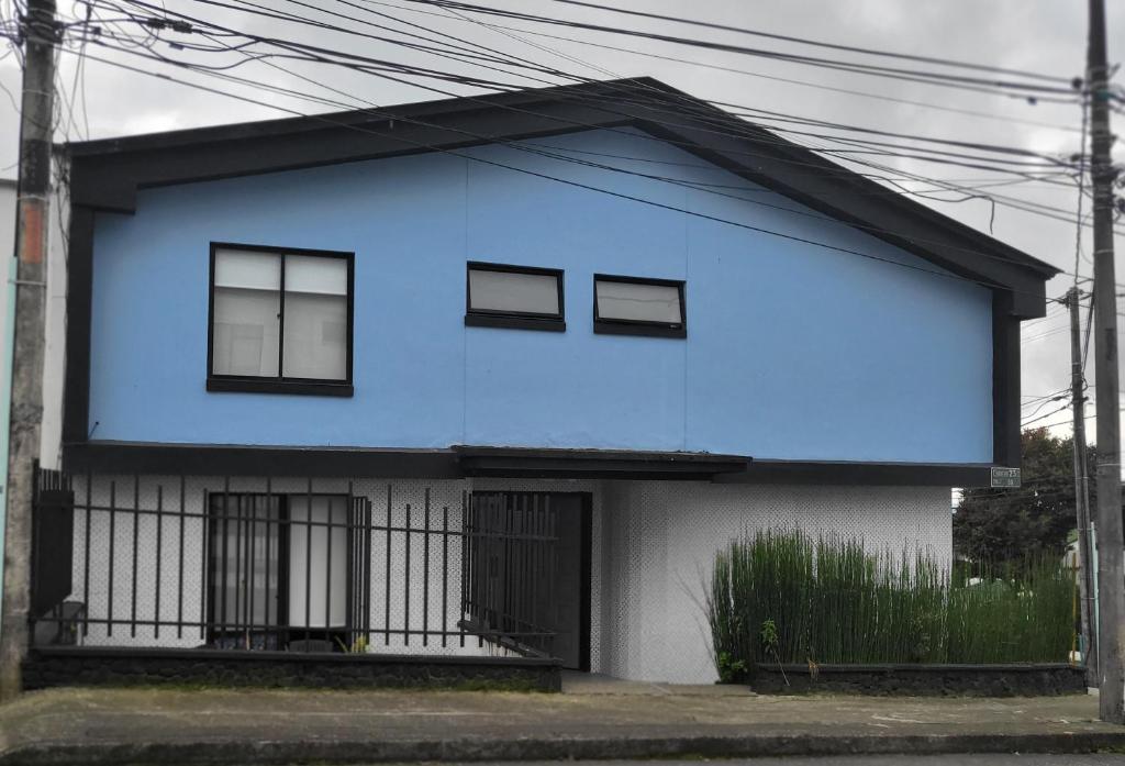 马尼萨莱斯Casa Azul的蓝色和白色的房子,设有黑窗