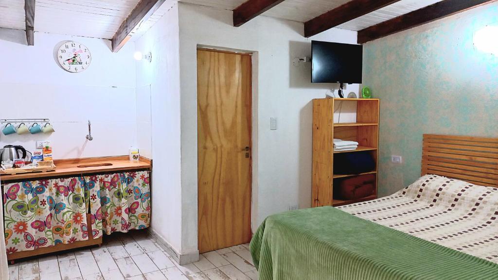 伊图萨因戈Dona Monica的一间卧室配有一张床和一个带电视的梳妆台