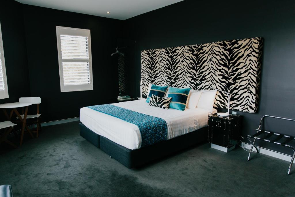 纽卡斯尔将克森酒店的一间卧室配有一张带蓝色和白色枕头的床