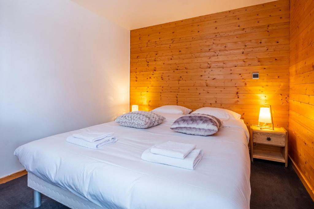 夏蒙尼-勃朗峰La Chapelle Aux Pieds Des Pistes的卧室配有白色的床和木墙