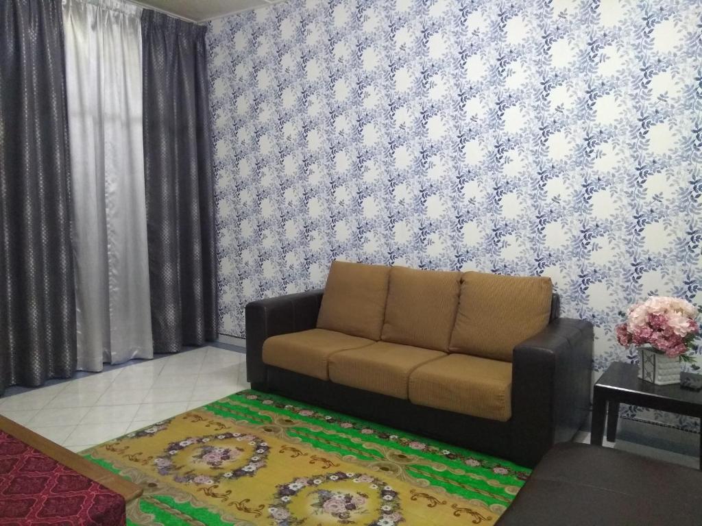 Kampong BinjaiRumah Tamu AZ Pasir Tumboh的带沙发和地毯的客厅