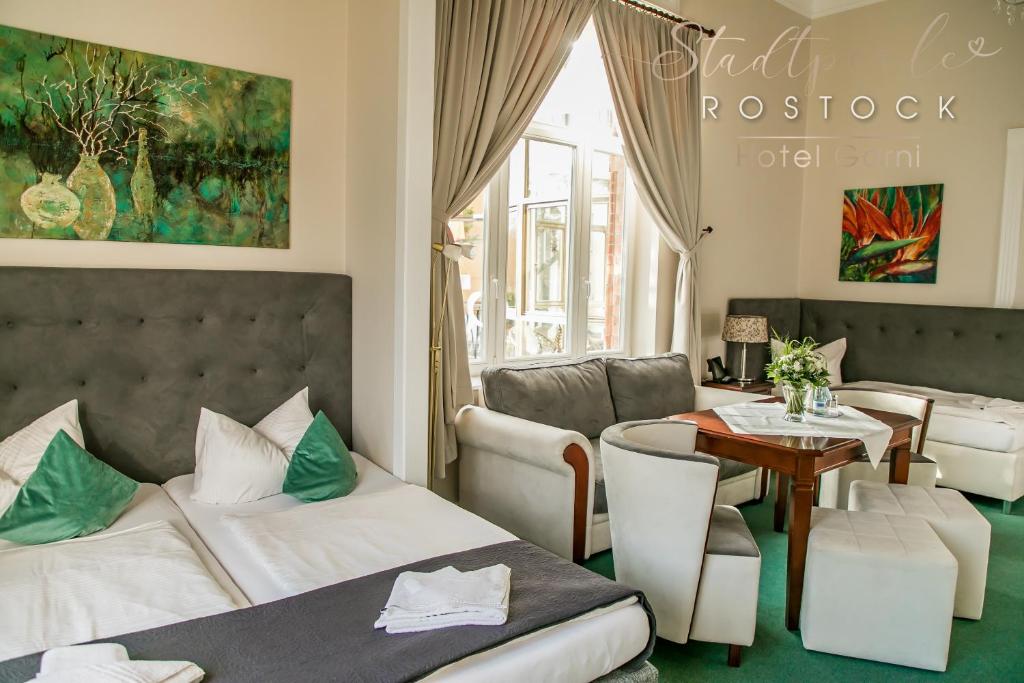 罗斯托克洛斯托克斯达特皮尔酒店的酒店客房带一张床、一张桌子和椅子