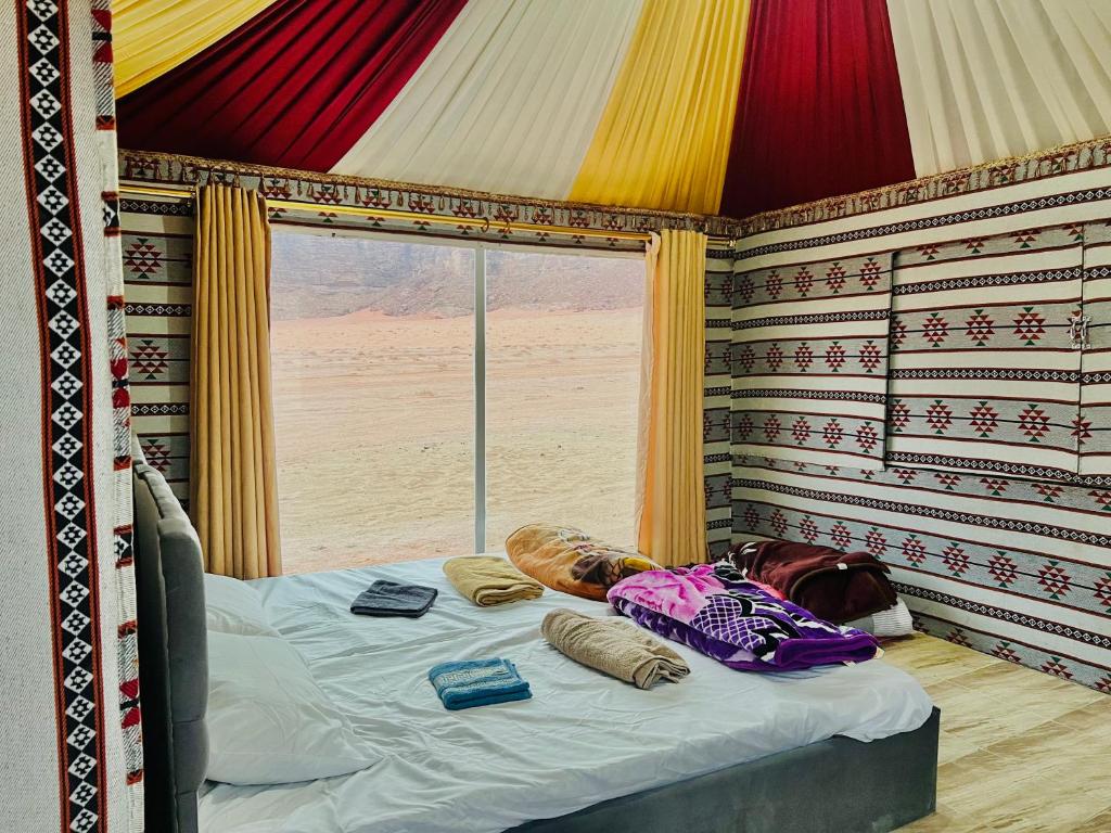 瓦迪拉姆Wadi Rum Cave Camp &Jeep Tour的一间带床的卧室,位于带窗户的房间内