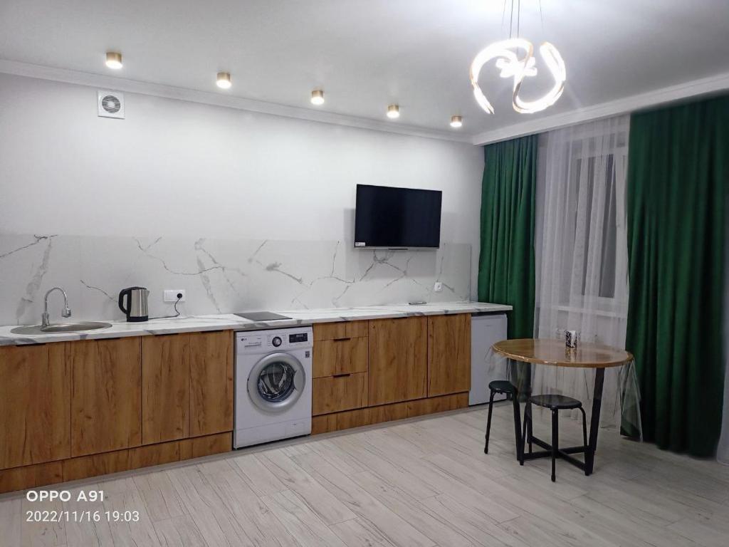 科克舍套Мухтара Ауэзова 205的厨房配有洗衣机和桌子