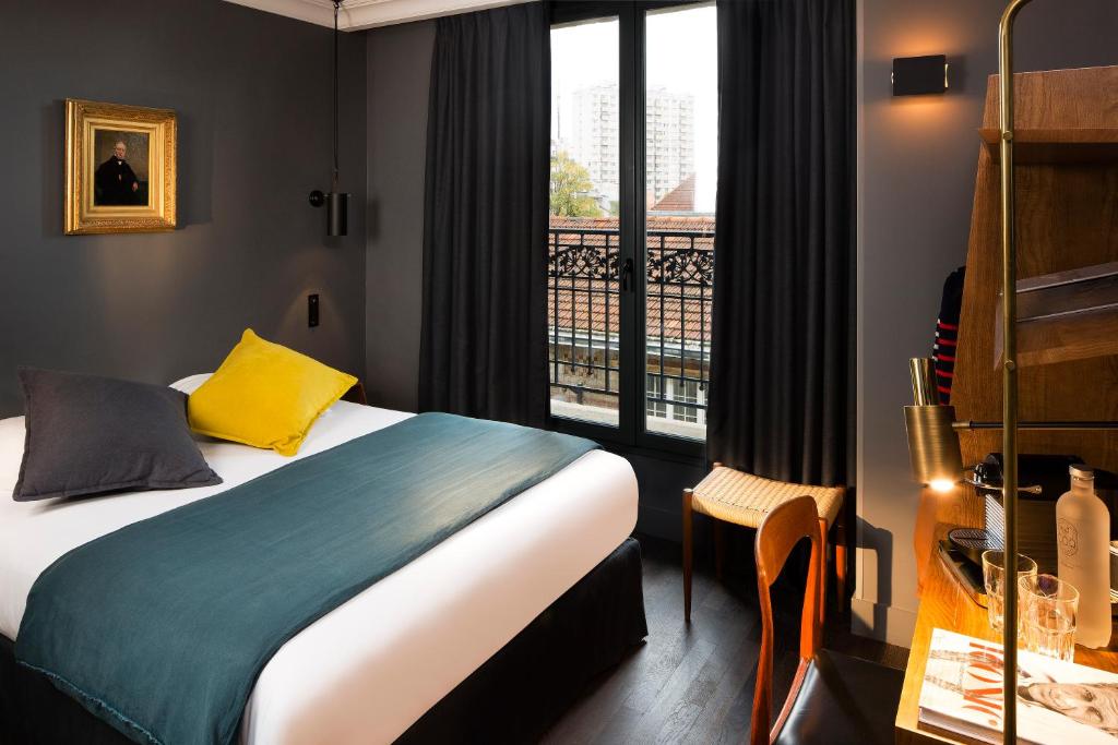 巴黎巴黎COQ酒店的酒店客房设有一张床和一个阳台。
