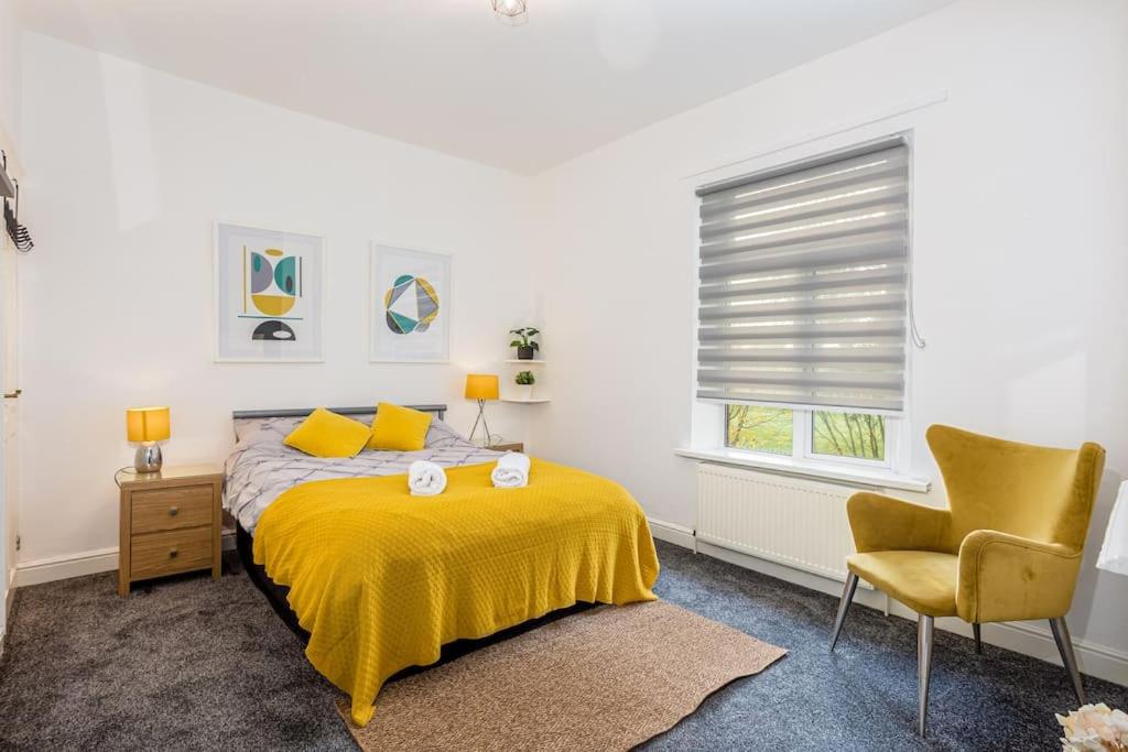 莱姆河下游的纽卡尔斯Stylish 3 Bedroom Central Property的一间卧室配有黄色的床和椅子