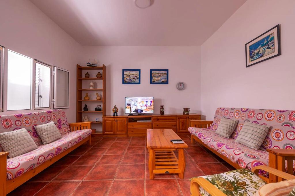 Las Marciegas3 bedrooms house at Los Caserones 50 m away from the beach with enclosed garden and wifi的客厅配有两张沙发和一台电视机