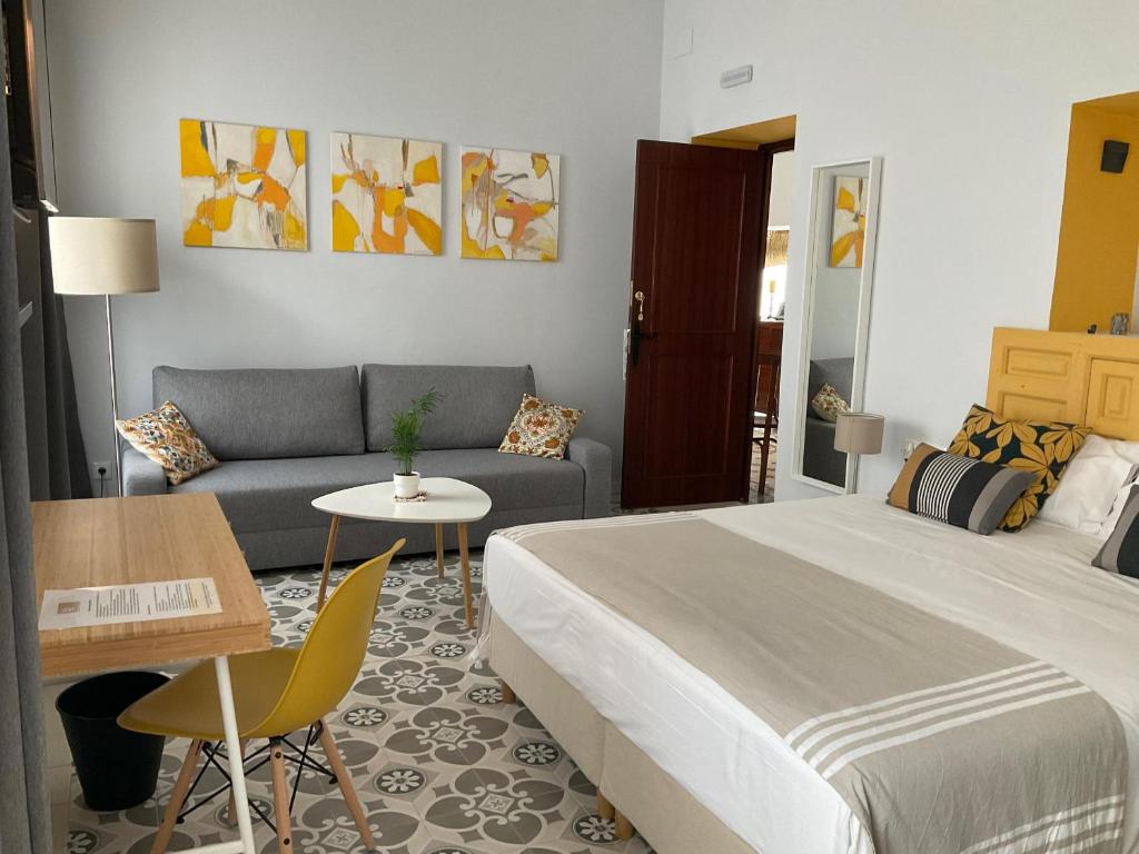 桑卢卡尔-德巴拉梅达Casa de las Especias Hotel Boutique的一间卧室配有一张床、一张沙发和一张桌子