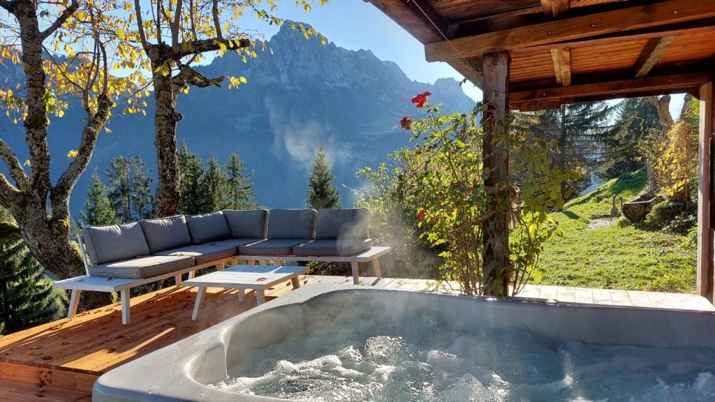 RougemontGstaad Paradise View Chalet with Jacuzzi的美景房屋甲板上的热水浴池