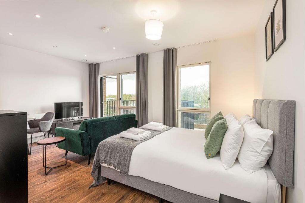 伦敦Stayo Apartments Barking Wharf的酒店客房设有一张大床和一张书桌。