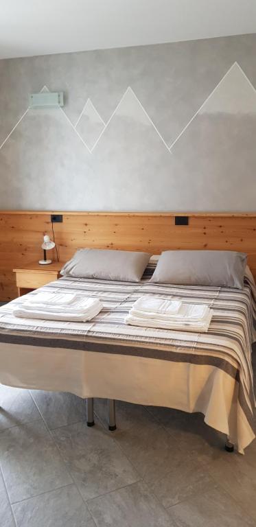 泰廖Il Mulinel agriturismo的一间卧室配有一张大床和木制床头板