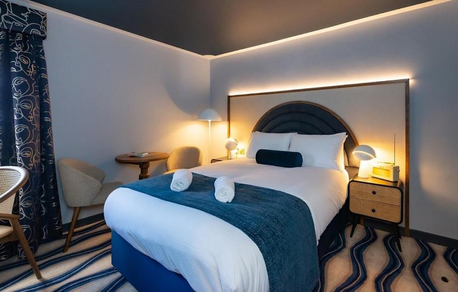 浦耳The Anchorage的酒店客房配有一张带蓝色毯子的大床