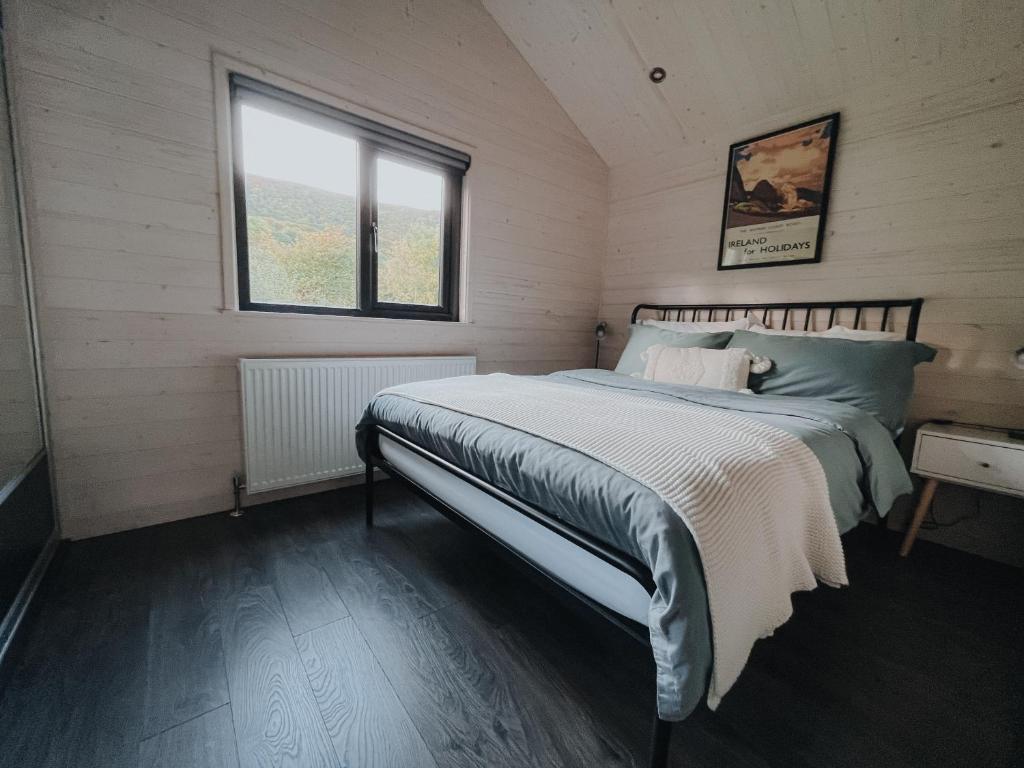 GlenarmBriarfield Farm Stays - A Unique Coastal Getaway的一间卧室设有一张床和一个窗口