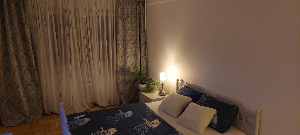 考纳斯Pakeliui的一间卧室配有一张带蓝色和白色枕头的床