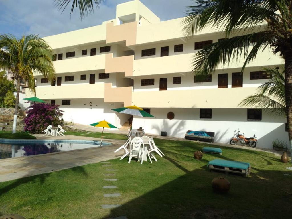阿奎拉兹Hotel Pousada Summer Way的一座带游泳池和椅子的建筑和一座建筑