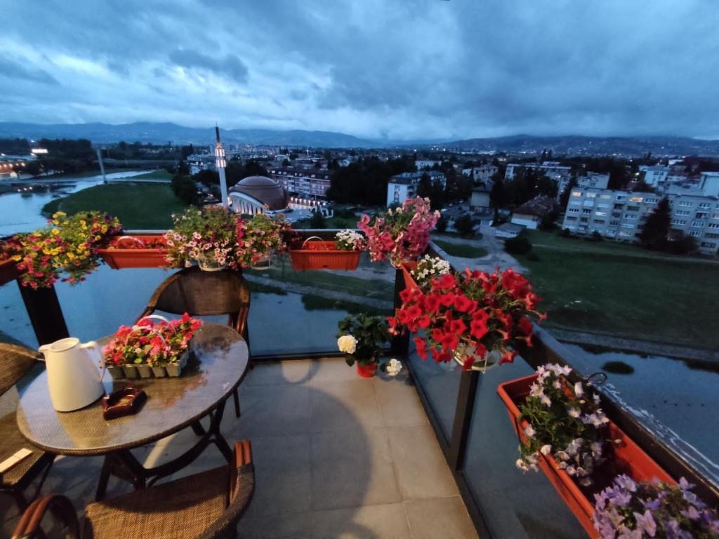 萨拉热窝شقة نهر اليجا的阳台配有桌子和鲜花