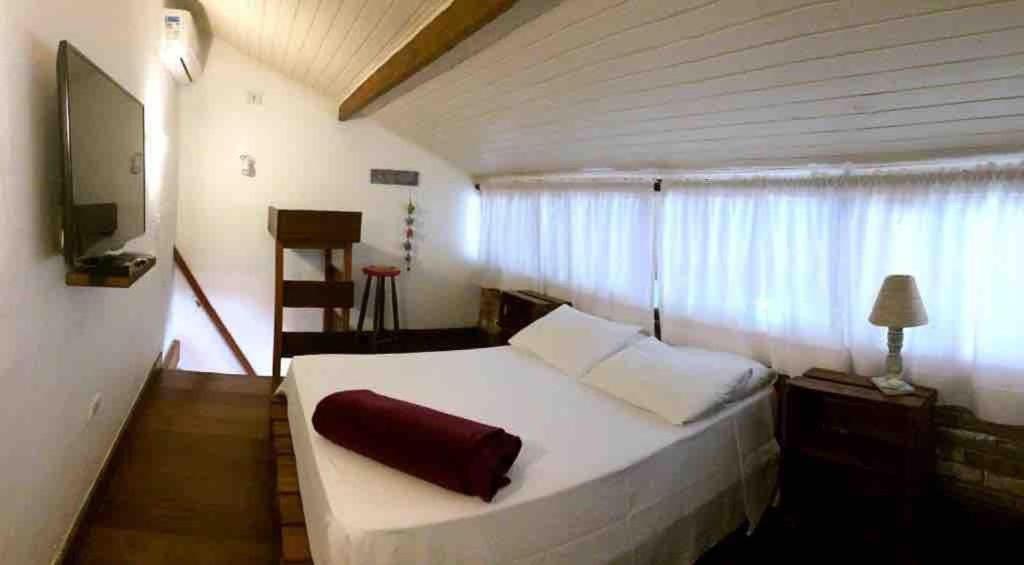 马利西亚斯Chalés Água Grande的卧室设有一张白色大床和一扇窗户。
