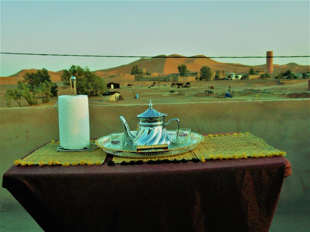 梅尔祖卡Hostel Merzouga Tifinagh的茶壶和蜡烛的桌子