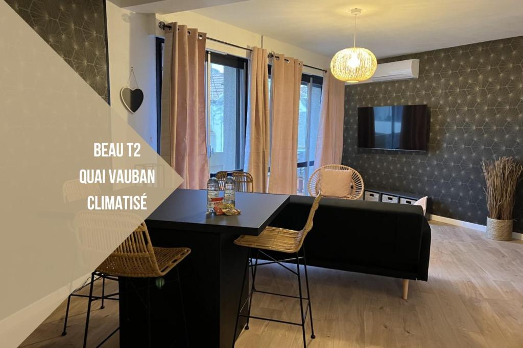 佩皮尼昂Perpignan Vauban magnifique T2 avec balcon的厨房以及带黑色柜台和椅子的用餐室